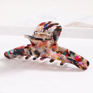 Detail view of large marble texture hair claw clip with colorful acetate pattern