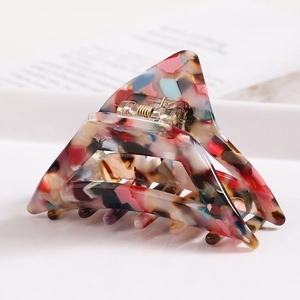 Detail of colorful acetate triangle hair claw clip with colorful stone pattern texture