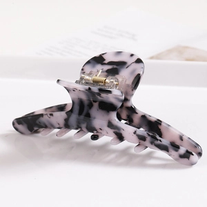 Detailed view of the durable metal spring and glossy marble texture on the acetate hair claw