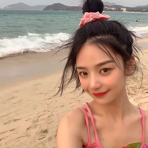 Pink fabric scrunchie for women tied on a bun hairstyle with beach vacation background