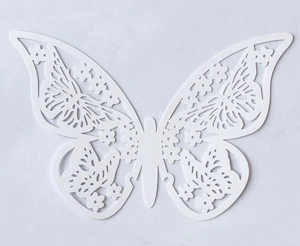 Detailed close-up of ivory pearlescent paper butterfly with 3D cutout floral patterns