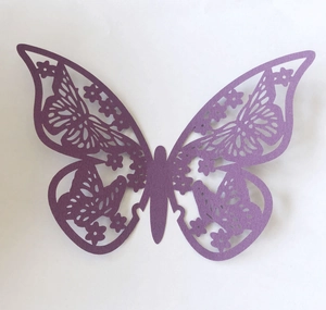 Close-up of purple pearlescent paper butterfly with detailed floral hollow carvings