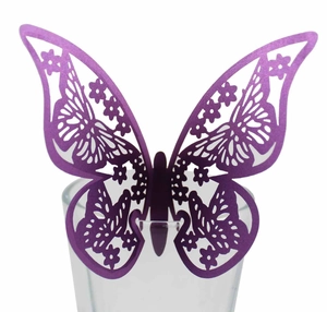 Close-up of a purple hollowed-out 3D paper butterfly decorative sticker on a glass rim