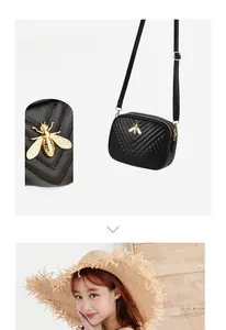 Detail of black V-quilted shoulder bag featuring a vintage gold bee buckle and strap