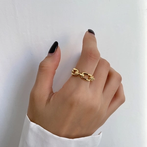 Detail of a gold chain link ring with a polished minimalist industrial design for women