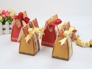 Détail de boîtes à bonbons de mariage chinoises avec nœuds en satin et motifs de vagues