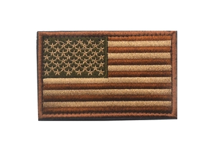 Close-up of olive green and tan tactical US flag patch showing embroidery texture