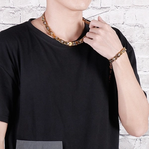 Detail showing gold and silver magnetic clip necklace and bracelet set on a male model