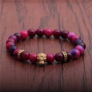 8mm Perlenarmband aus violettem Achat mit goldenem Totenkopf auf dunklem Hintergrund