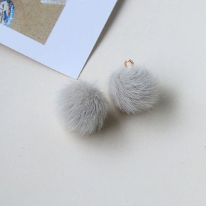 Detail of light gray fluffy faux fur pompom pendant with metal loop for DIY jewelry making