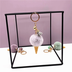 Detail of plush ice cream keychains featuring fluffy faux fur balls and golden cones
