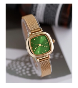 Close-up of rose gold rectangular watch with green sunburst dial and mesh steel band