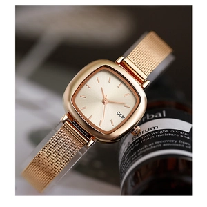 Close-up of elegant small square gold mesh strap watch with a minimalist dial