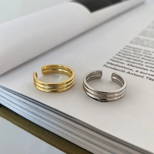 Macro shot of minimalist S925 sterling silver parallel band rings on a book page