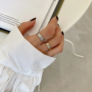 Detail of gold and silver textured multi-layer rings worn on hand for a chic punk style