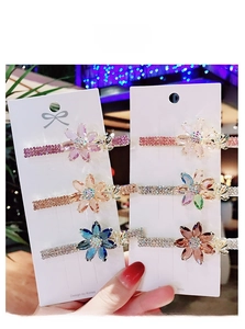 Detailed close-up of six colorful crystal flower hair clips with sparkling rhinestone inlay
