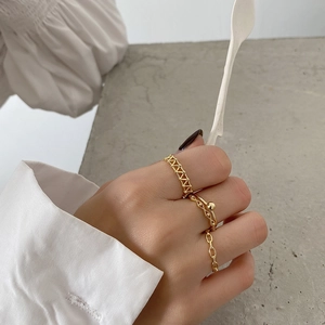 Golden 925 sterling silver ring set featuring geometric and chain link designs on model hand