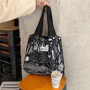 Detail of canvas tote bag showing abstract line art patterns and large storage capacity