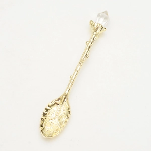 Vintage golden alloy coffee spoon with crystal head and intricate floral embossed patterns