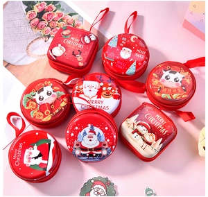 Detailed view of red Christmas tinplate coin purses with festive cartoon patterns and zippers