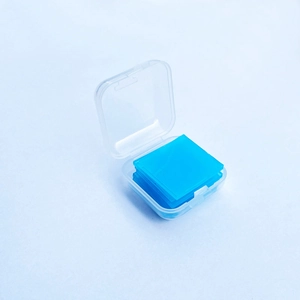 Close-up of blue square drill wax pieces neatly stacked in a clear plastic organizer box