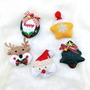 Close-up of assorted Christmas plush brooches with Santa, reindeer and tree on fur