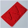 Detail view of red silicone mold featuring three festive Christmas tree shapes for baking