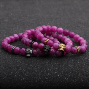 Set di bracciali con perle viola e teschi metallici nei colori argento, nero e oro