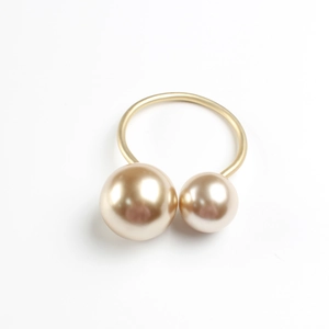 Detailed view of matte gold napkin ring featuring elegant double champagne pearls