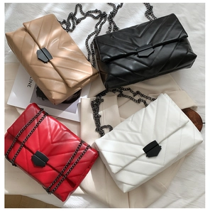 Detail view of quilted chain bags in black, white, red, and khaki with V-pattern stitching