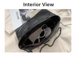 Top view of black quilted chain bag interior with brown lining showing storage space