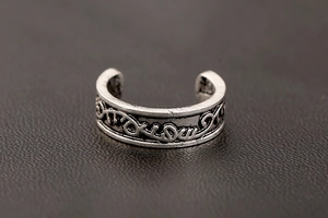 Macro shot of vintage silver ear cuff featuring detailed vine engraving and antique finish