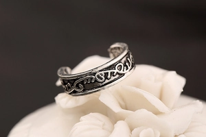 Macro detail of retro engraved leaf pattern on vintage silver adjustable toe ring