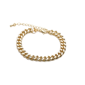 Detailed close-up of gold-plated Cuban link bracelet with lobster clasp and extension chain