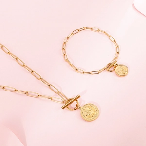 Ensemble collier et bracelet à maillons trombone dorés avec pendentif pièce et fermoir T