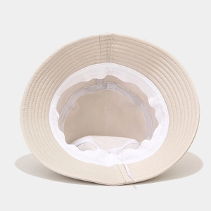Inside view of a beige cotton bucket hat showing the sweatband and adjustable drawstring