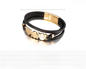 Detail of multi-layer black leather punk bracelet with gold skulls and magnetic clasp