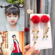 Close-up of red pompom hair clips with pearl tassels and bells for traditional Hanfu outfit