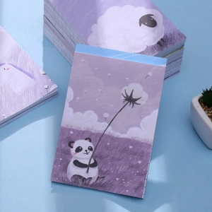 Close-up of cute cartoon notepad with panda illustration on a soft blue background