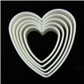 Close-up of heart-shaped plastic cookie cutters in nested arrangement on black surface