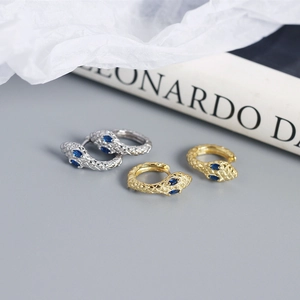 Close-up of S925 sterling silver snake hoop earrings with blue gemstone eyes