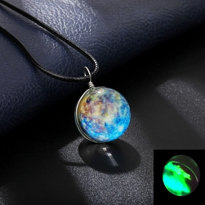 Macro detail of cosmic glass sphere pendant showing vibrant glow-in-the-dark luminous effect