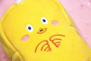 Close-up of yellow plush cartoon chicken pencil case showing detailed embroidery and soft texture