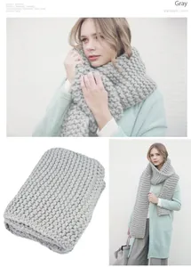 Detail view of thick gray knit scarf showing chunky weave texture and stylish fit