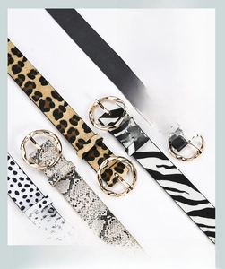 Detail of five stylish belts with leopard, zebra, and snake prints and gold buckles