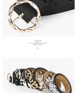 Close-up of golden wavy round buckle and assorted animal print fashion belts
