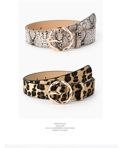 Detail view of stylish leopard and snake print belts with round gold buckles for dresses
