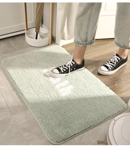 Detail of light green HOME bath mat with soft plush texture and non-slip surface