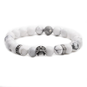 Gothic 8mm white turquoise bead bracelet with a silver skull charm on a plain background