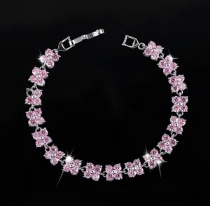 Dettaglio del bracciale a fiori argentato con petali in zircone rosa su sfondo nero puro